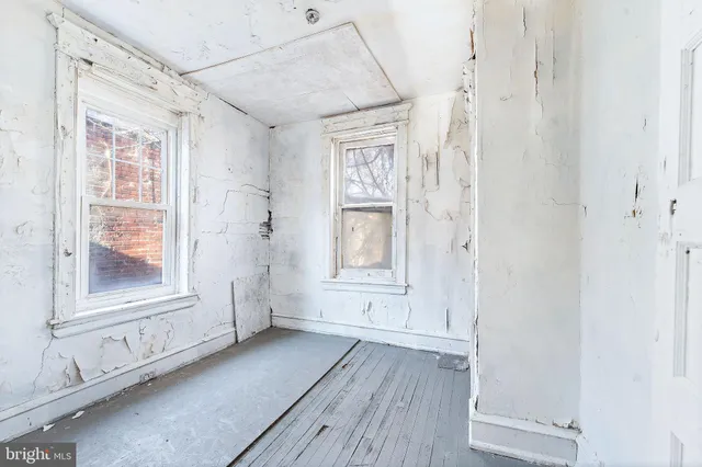 a view of empty room with window and wooden floor