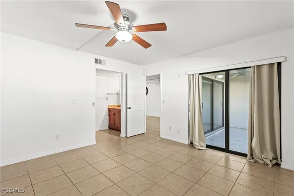 an empty room with fan and entrance