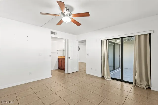 an empty room with fan and entrance