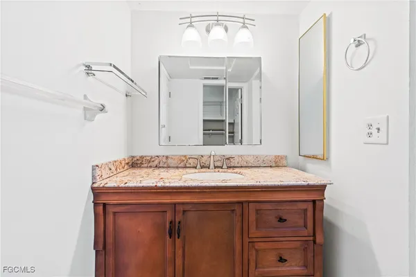 a bathroom with a granite countertop sink and a mirror