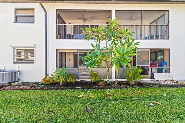 a front view of a house with a yard and potted plants