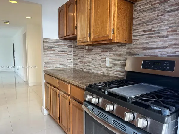 a kitchen with granite countertop stove and cabinets