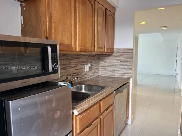 a kitchen with stainless steel appliances granite countertop a sink stove and microwave