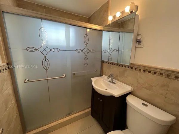 a bathroom with a sink a toilet and mirror
