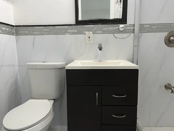 a bathroom with a sink vanity mirror and toilet