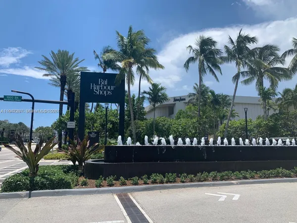 a view of a patio with table and chairs potted plants and palm tree