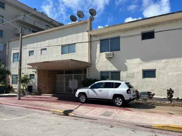 a car parked in front of a white house