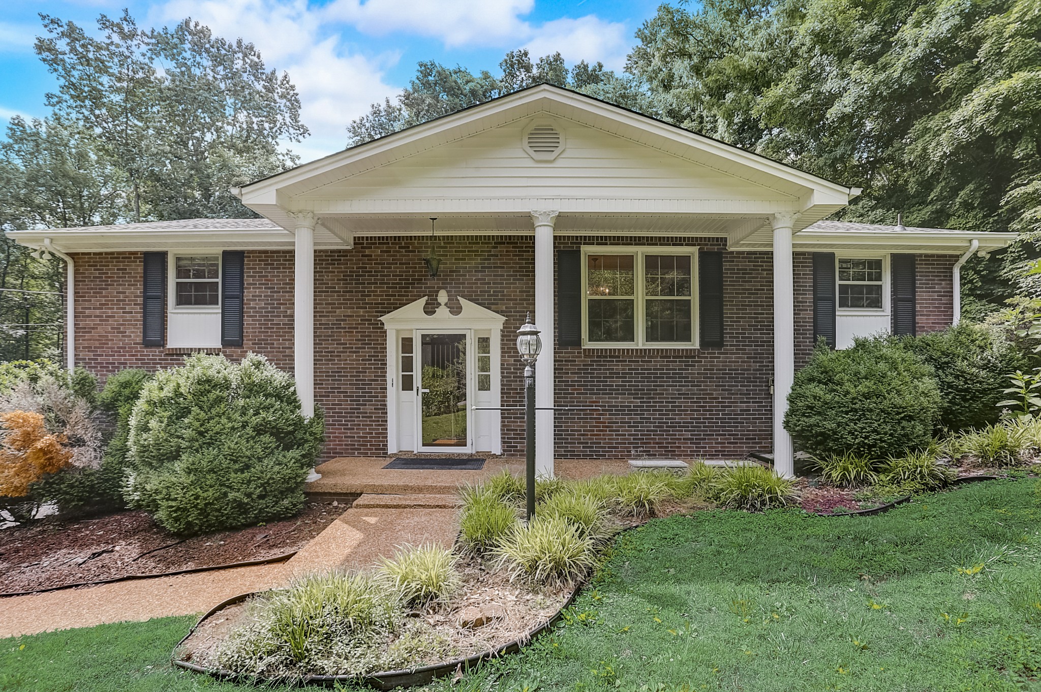 112 Lee Road Dickson, TN 37055 - Photo 1 of 29 a view of a brick house with a yard potted plants and a table