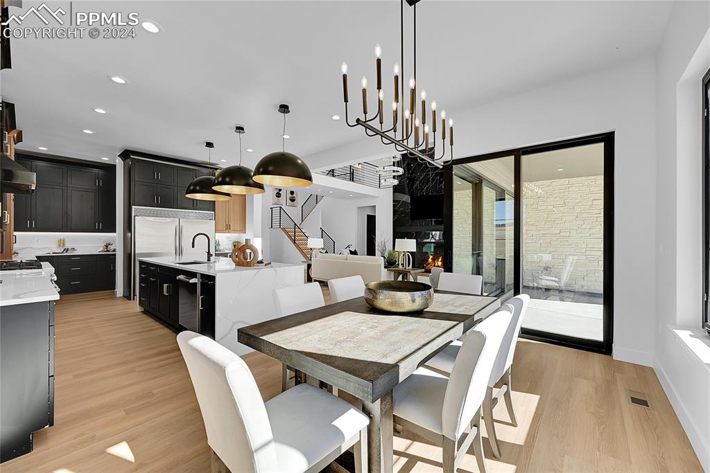 5549 Remuda Ranch Parkway Sedalia, CO 80135 - Photo 13 of 39 a view of a dining room with furniture a chandelier and wooden floor