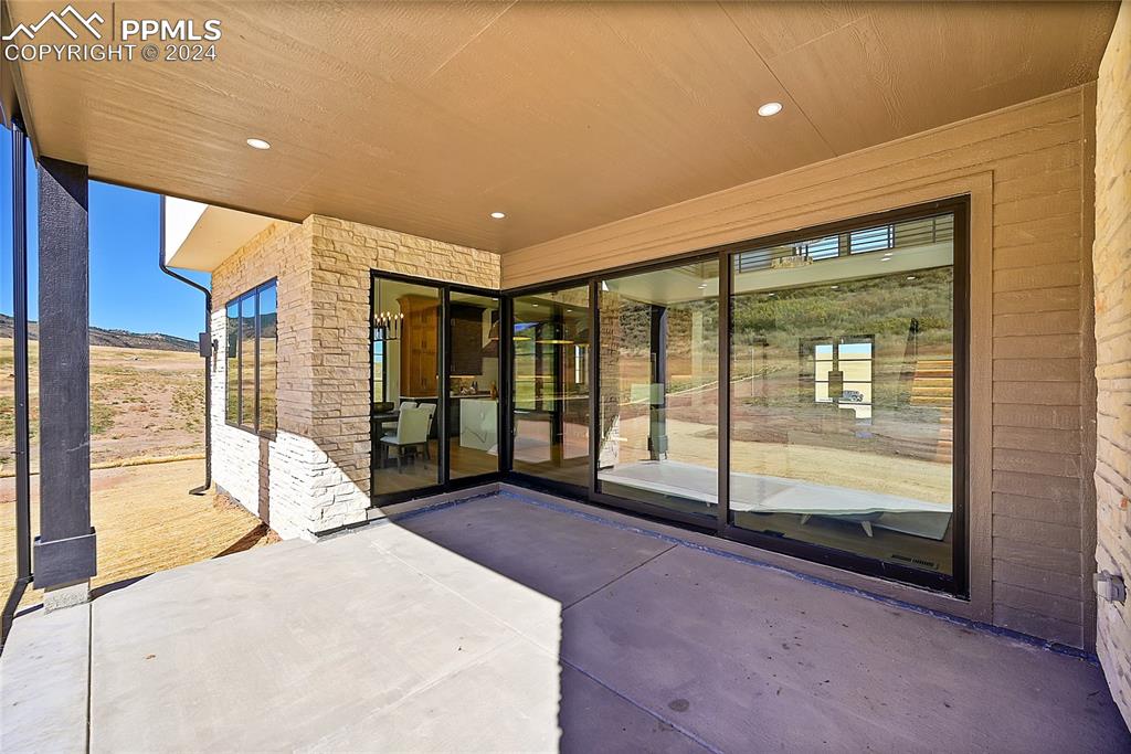 5549 Remuda Ranch Parkway Sedalia, CO 80135 - Photo 33 of 39 a spacious bedroom with a large window and a chandelier