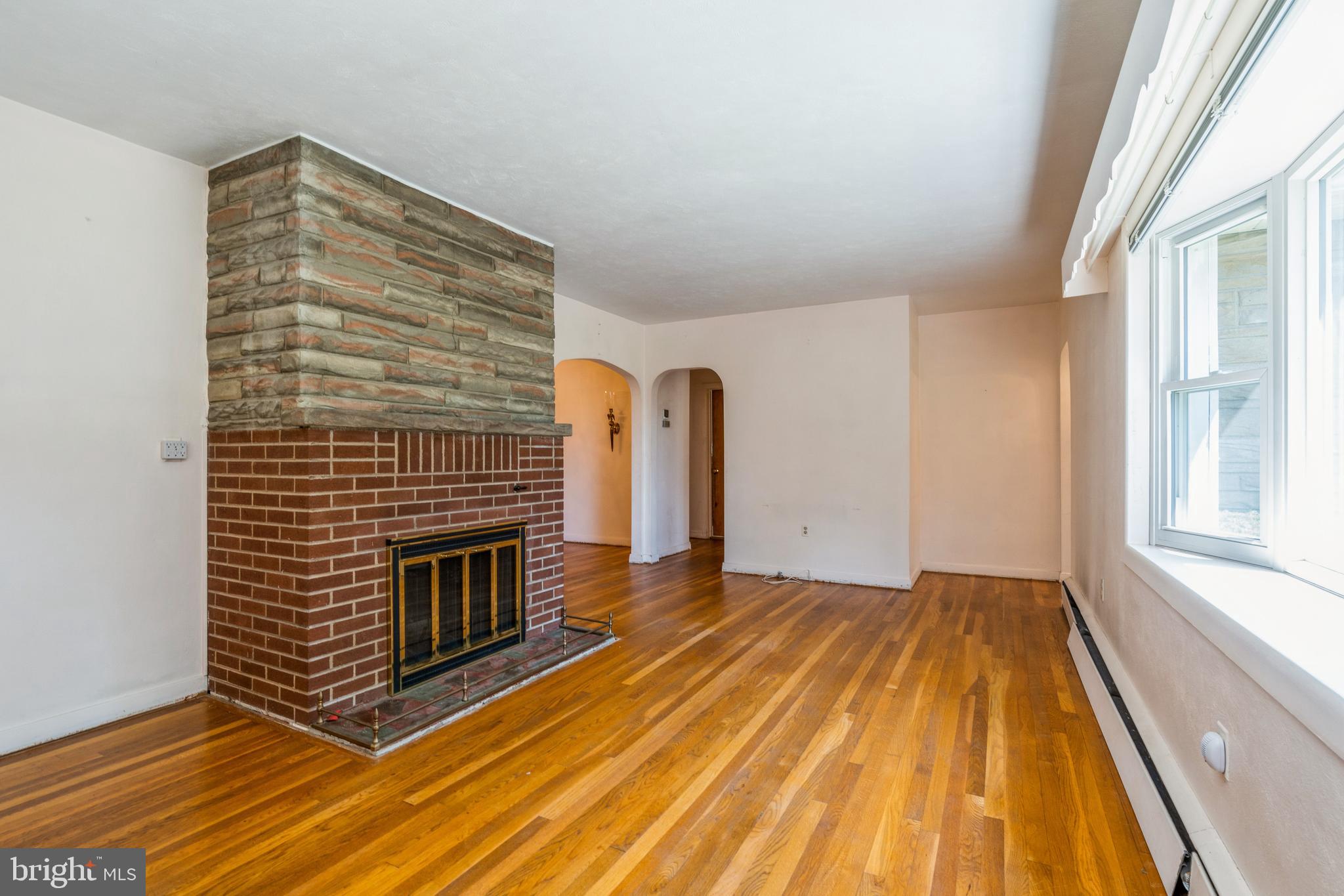 112 Wilburtha Road Ewing, NJ 08628 - Photo 5 of 21 a view of an empty room with exposed radiator and fireplace