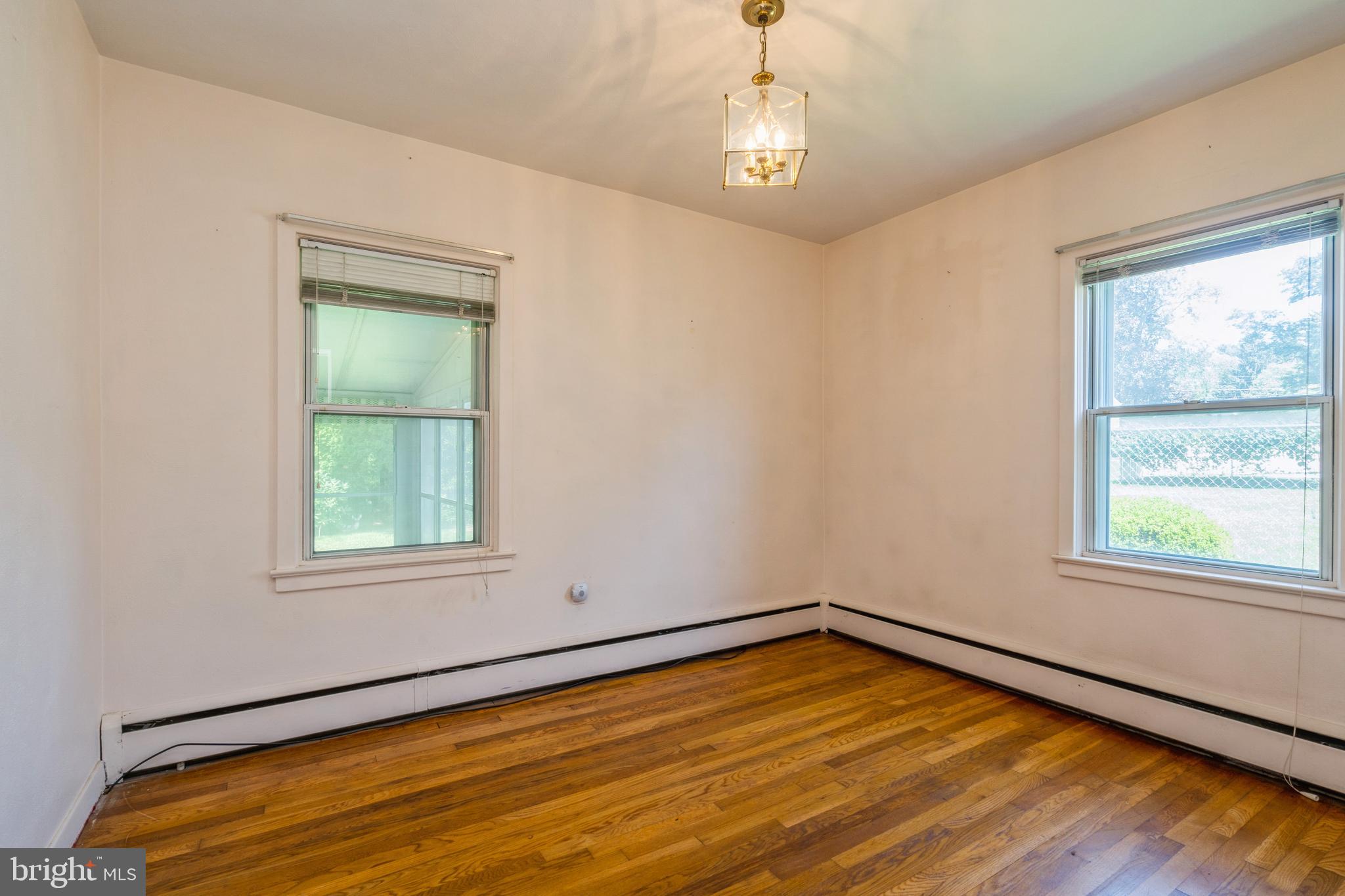 112 Wilburtha Road Ewing, NJ 08628 - Photo 10 of 21 a view of an empty room with wooden floor and a window