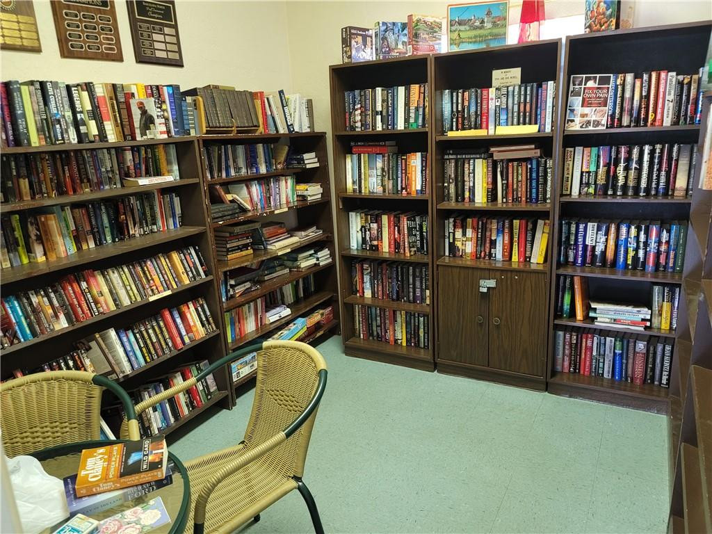 251 South Cypress Road, Unit 112 Pompano Beach, FL 33060 - Photo 17 of 20 a view of a workspace with bookshelf and a wooden floor