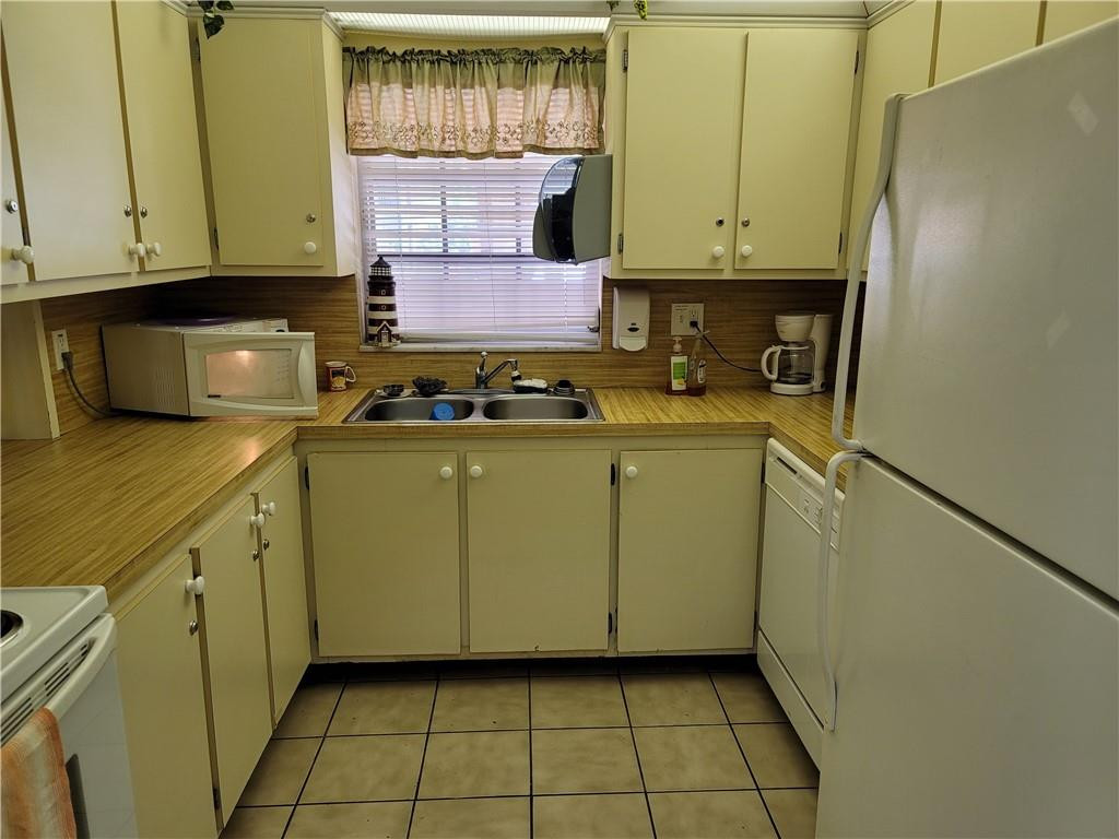 251 South Cypress Road, Unit 112 Pompano Beach, FL 33060 - Photo 18 of 20 a kitchen with stainless steel appliances granite countertop a refrigerator a stove and a sink