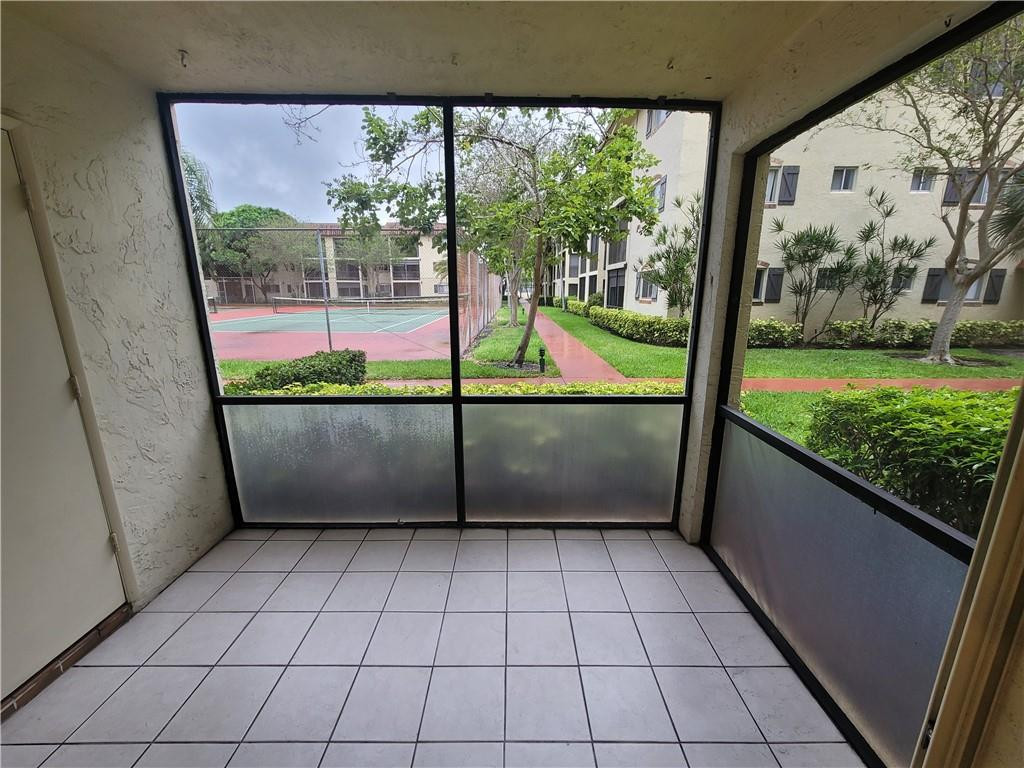 251 South Cypress Road, Unit 112 Pompano Beach, FL 33060 - Photo 2 of 20 a view of a porch with wooden floor and outdoor space
