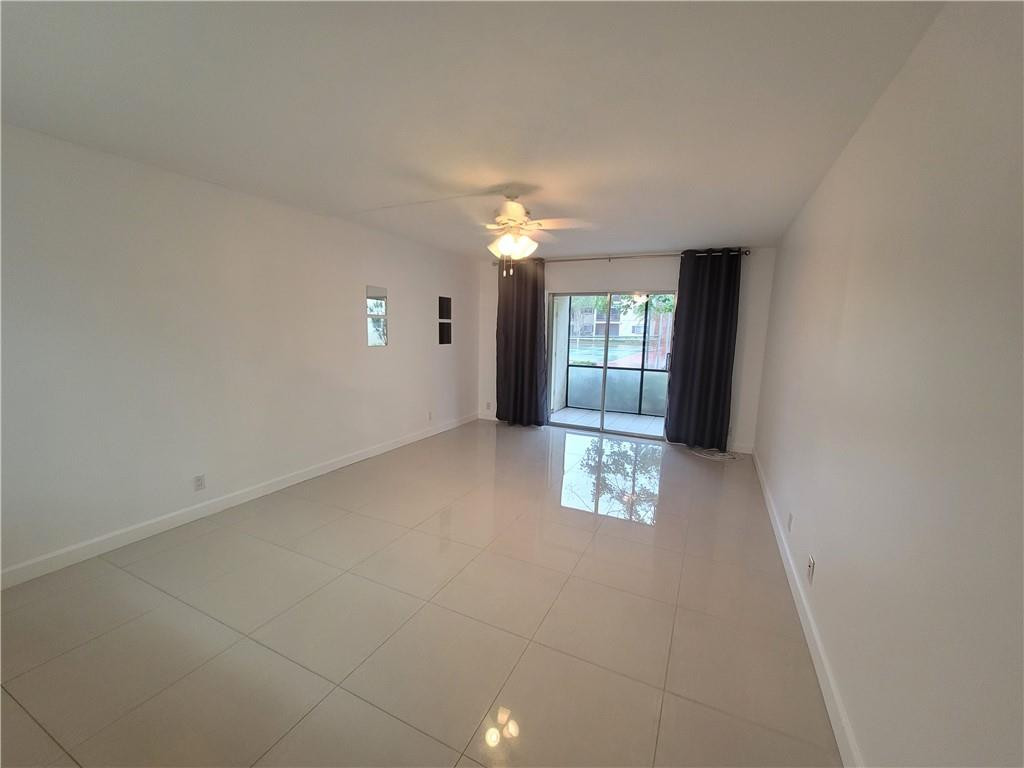 251 South Cypress Road, Unit 112 Pompano Beach, FL 33060 - Photo 4 of 20 an empty room with windows and fireplace