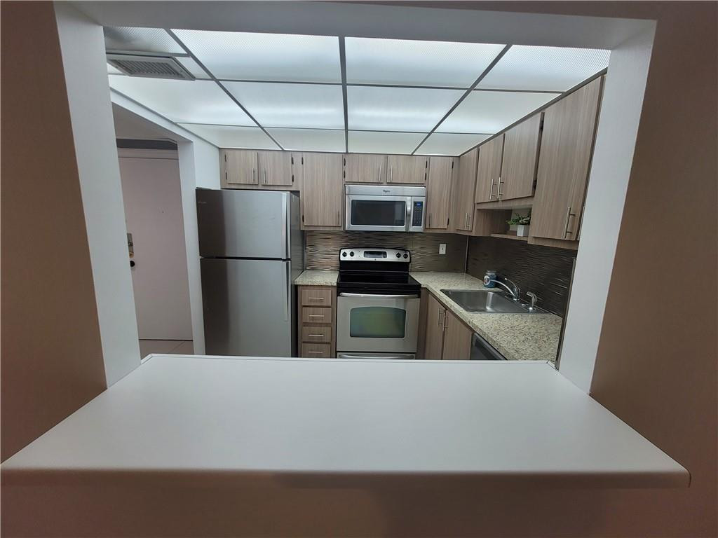 251 South Cypress Road, Unit 112 Pompano Beach, FL 33060 - Photo 5 of 20 a kitchen with cabinets and stainless steel appliances