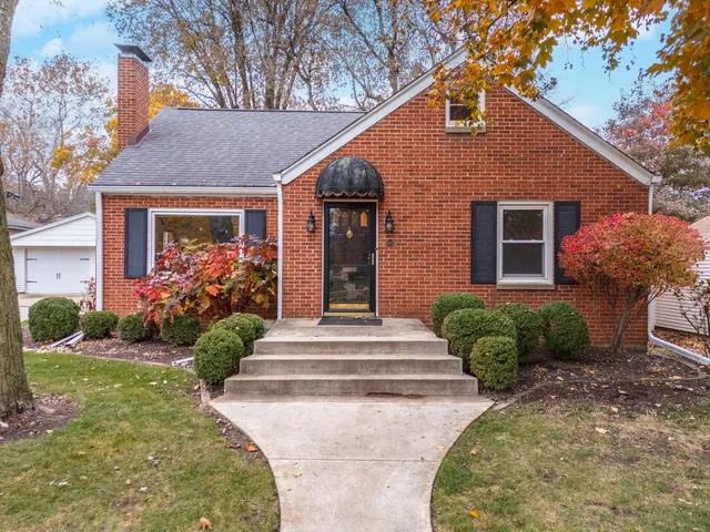 a front view of a house with plants and garden