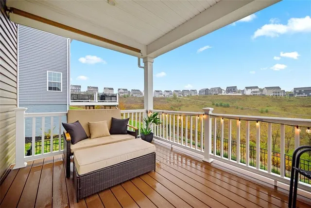 a balcony with wooden floor table and chairs