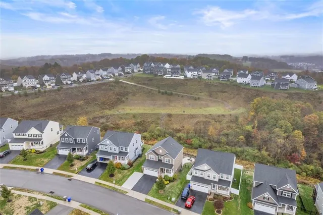 an aerial view of residential houses with outdoor space and ocean view