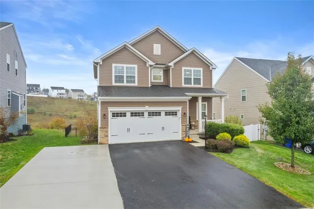 a front view of a house with a yard and garage