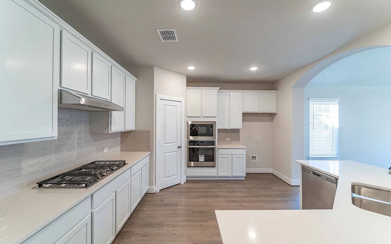 450 Durian Loop Buda, TX 78610 - Photo 12 of 17 A well-equipped culinary space featuring gleaming countertops and modern cooking appliances.