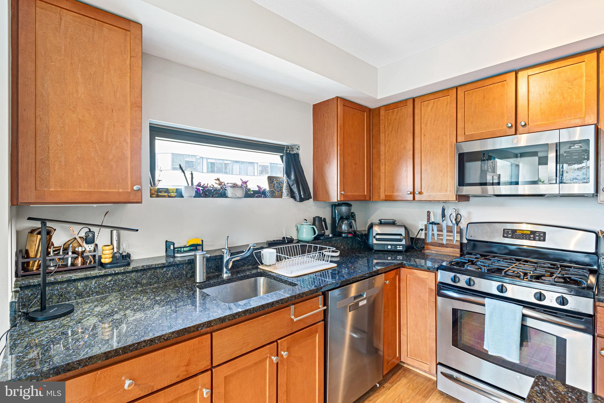 1117 10th Street Northwest, Unit 804 Washington, DC 20001 - Photo 15 of 46 a kitchen with stainless steel appliances granite countertop a sink stove and cabinets
