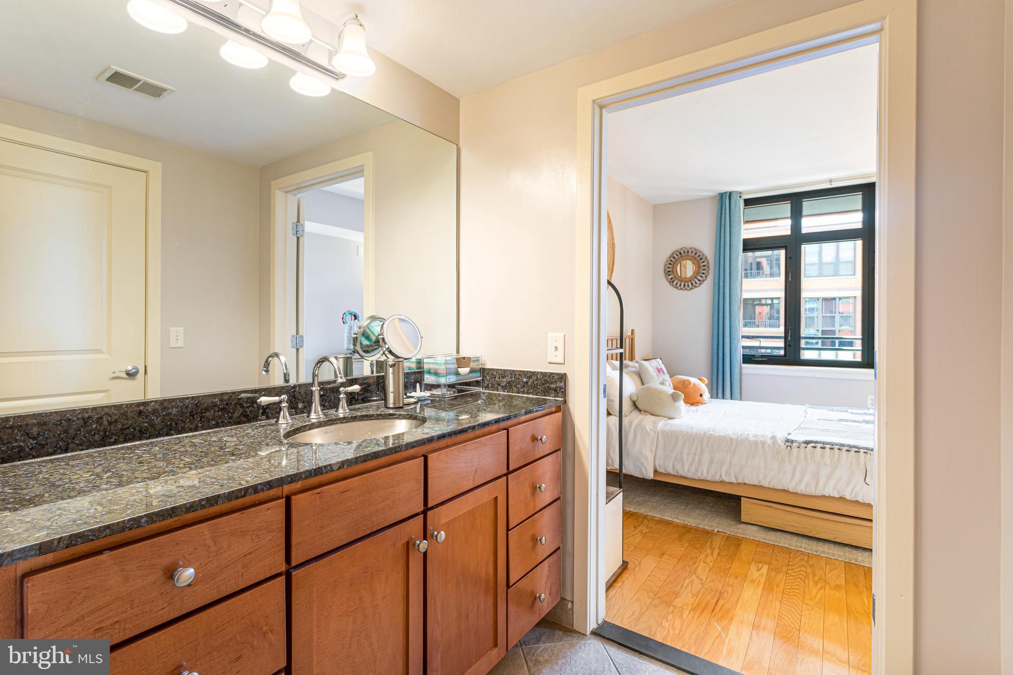 1117 10th Street Northwest, Unit 804 Washington, DC 20001 - Photo 23 of 46 a en suite bathroom with a granite countertop tub and a sink