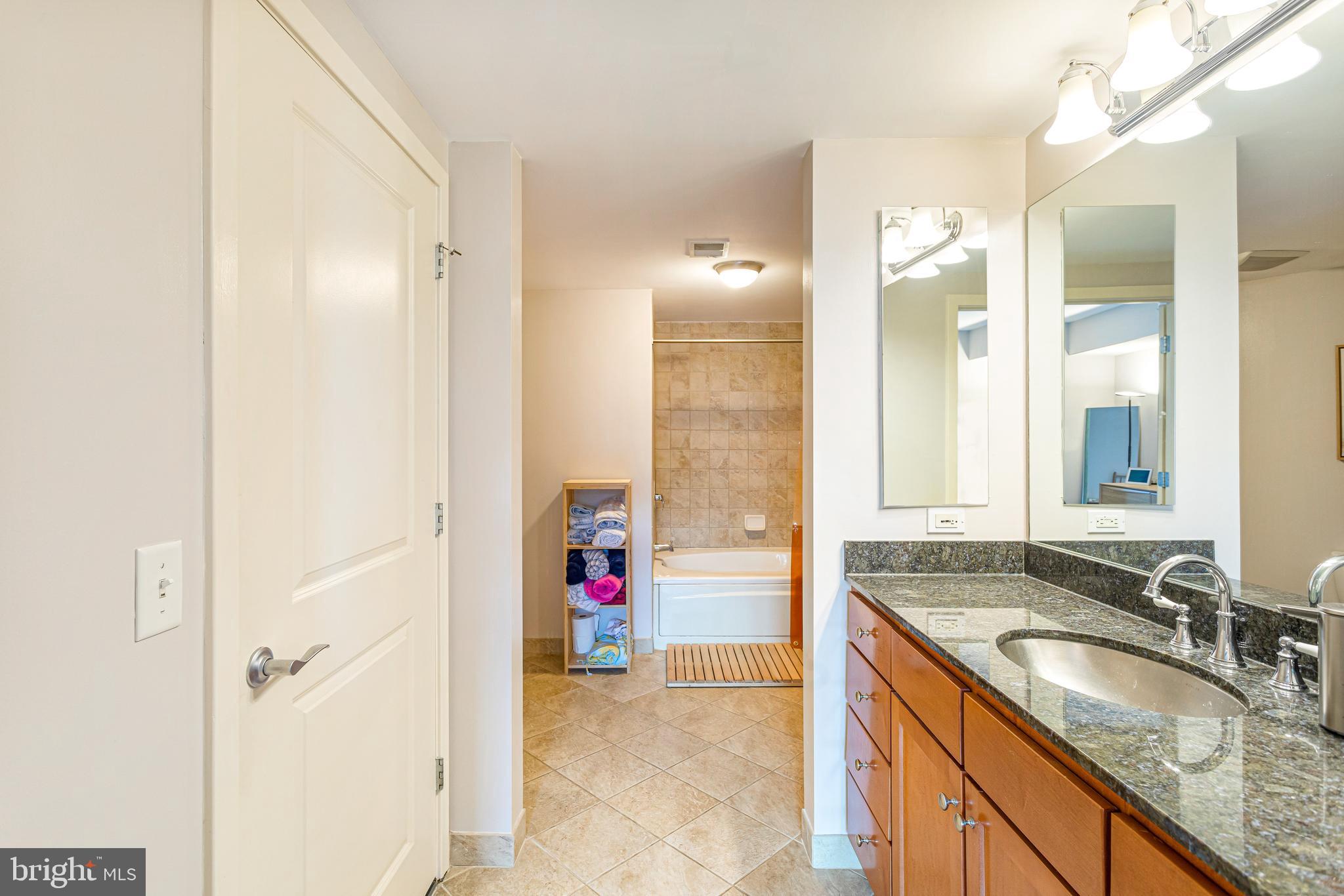 1117 10th Street Northwest, Unit 804 Washington, DC 20001 - Photo 24 of 46 a bathroom with a granite countertop sink and a mirror