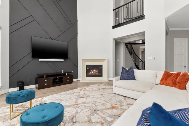 a living room with furniture a flat screen tv and a fireplace