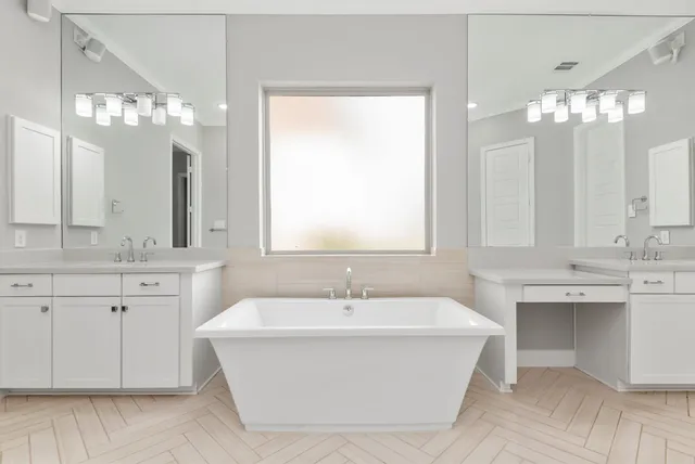 a spacious bathroom with a sink a large mirror and a bathtub