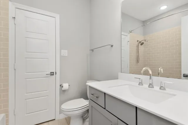 a bathroom with a sink a toilet and a mirror