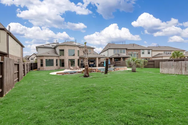 an aerial view of residential houses with outdoor space and parking