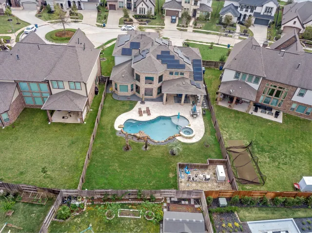 an aerial view of residential houses with outdoor space and lake view