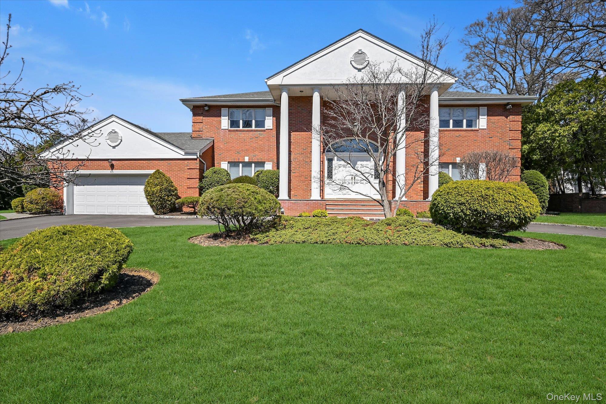 This charming brick home boasts a 2-car garage, a circular driveway, and gorgeous landscaping.