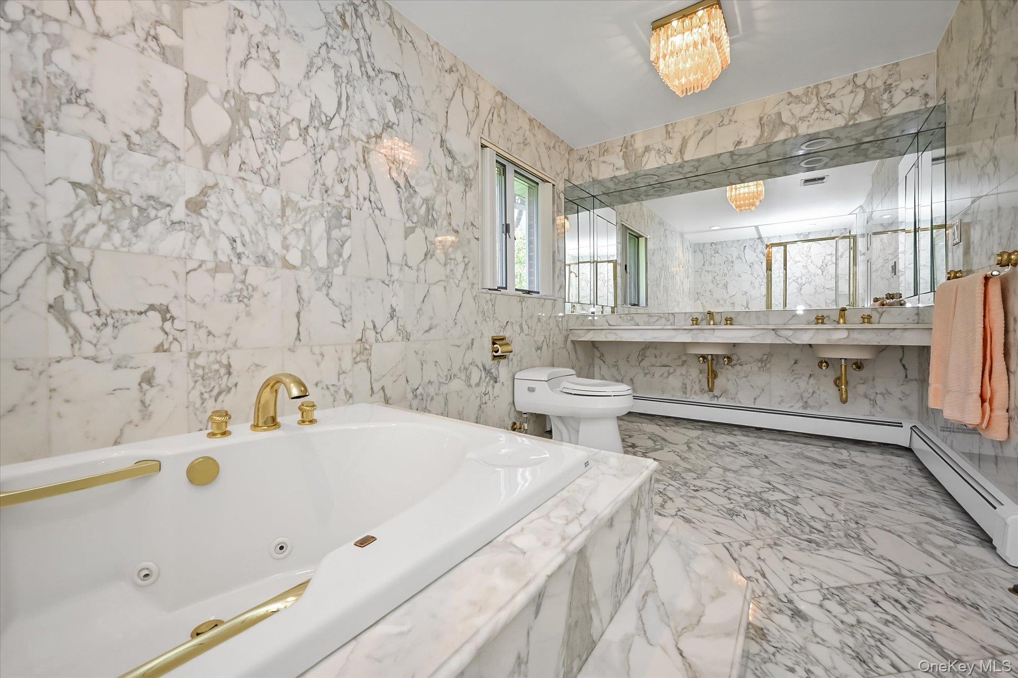 85 Meadow Woods Road Great Neck, NY 11020 - Photo 15 of 25 Primary bathroom viewed from another angle, featuring a vanity and mirrors.