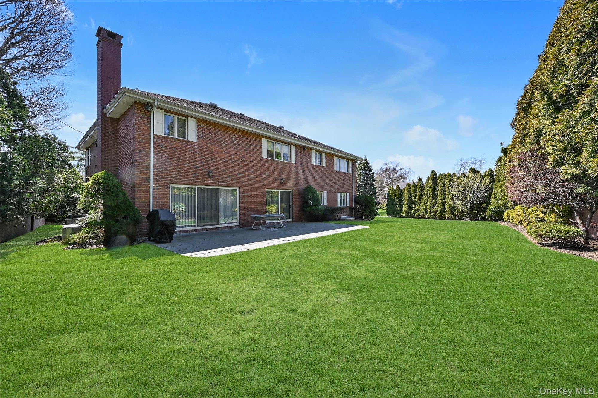 85 Meadow Woods Road Great Neck, NY 11020 - Photo 23 of 25 Enjoy over 17,000 square feet of privacy in your own backyard, featuring a patio and a gas line for your grill, surrounded by beautifully landscaped shrubs and a lush lawn.