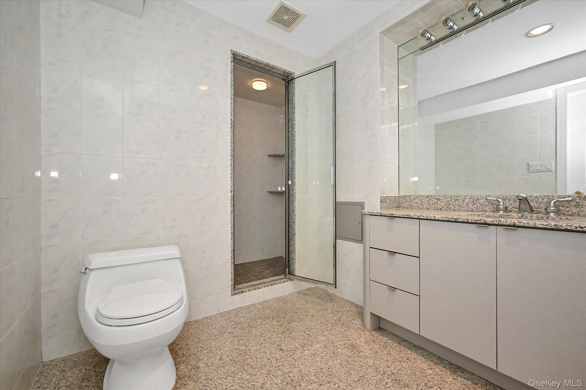 85 Meadow Woods Road Great Neck, NY 11020 - Photo 24 of 25 This bathroom in the recreation area features a stall shower and a granite countertop.