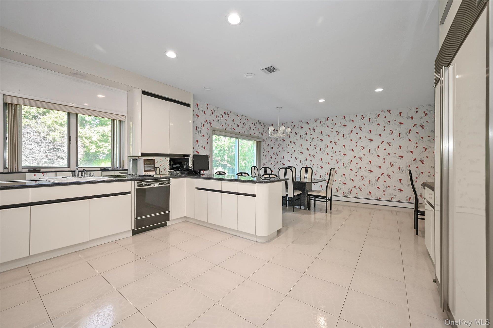 85 Meadow Woods Road Great Neck, NY 11020 - Photo 6 of 25 This spacious kitchen is a chef’s dream, featuring a Subzero fridge and granite counters with a peninsula that offers plenty of workspace.