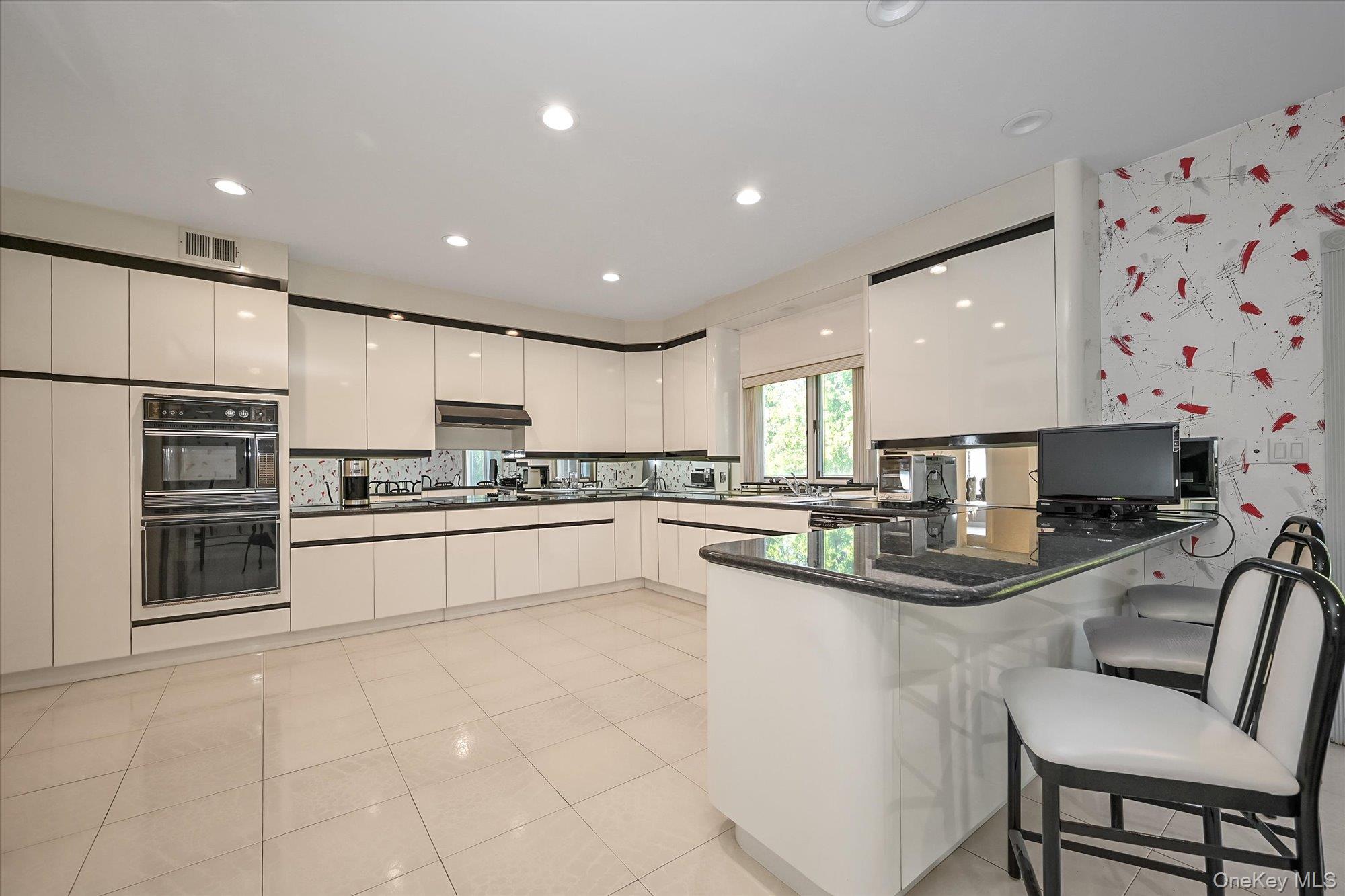 85 Meadow Woods Road Great Neck, NY 11020 - Photo 7 of 25 The kitchen peninsula doubles as a cozy breakfast spot with easy access to the yard.