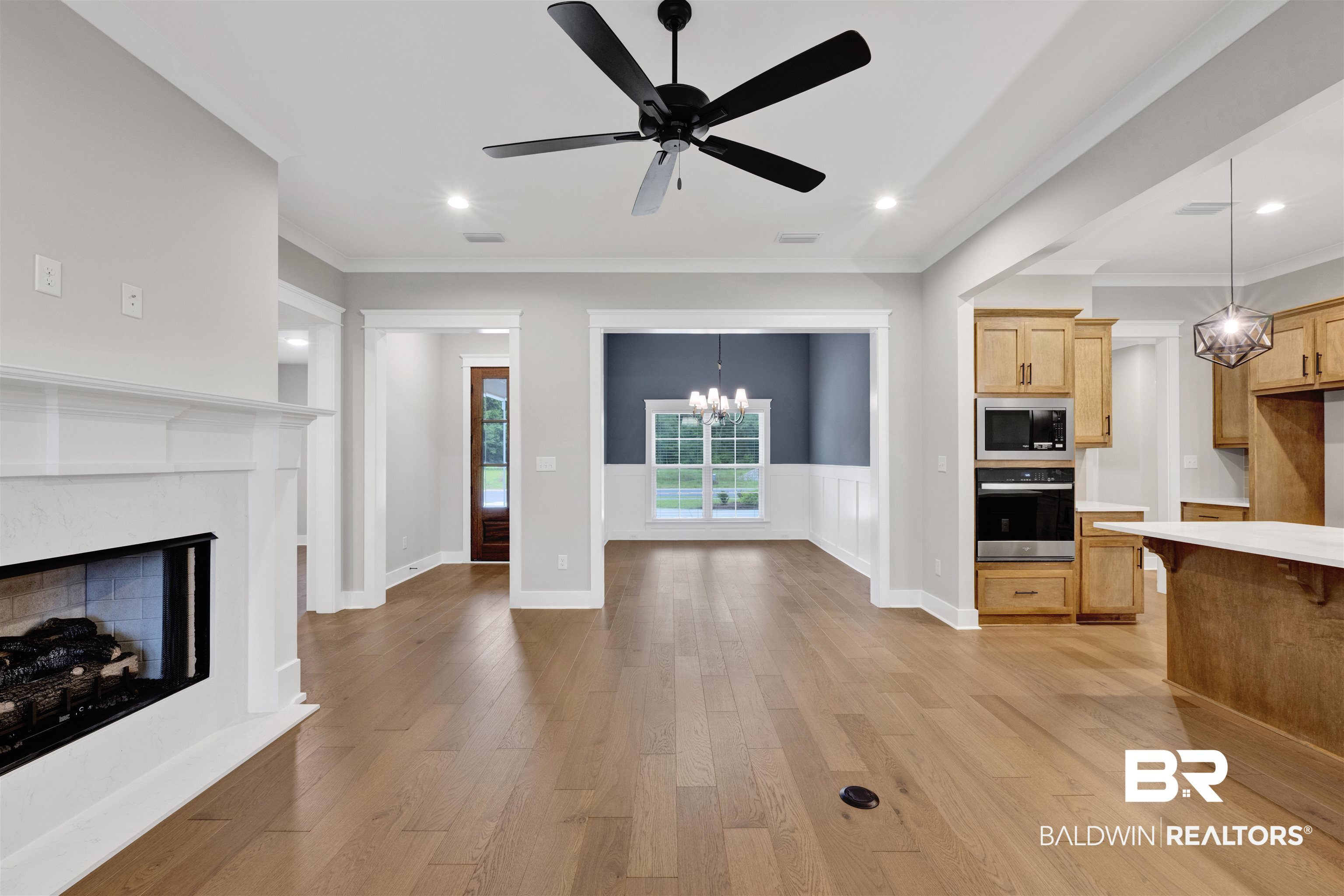 27371 Patch Pl Loop Daphne, AL 36526 - Photo 34 of 63 Open-concept living space featuring wood-finish flooring, a white mantel fireplace, recessed lighting, and a black ceiling fan