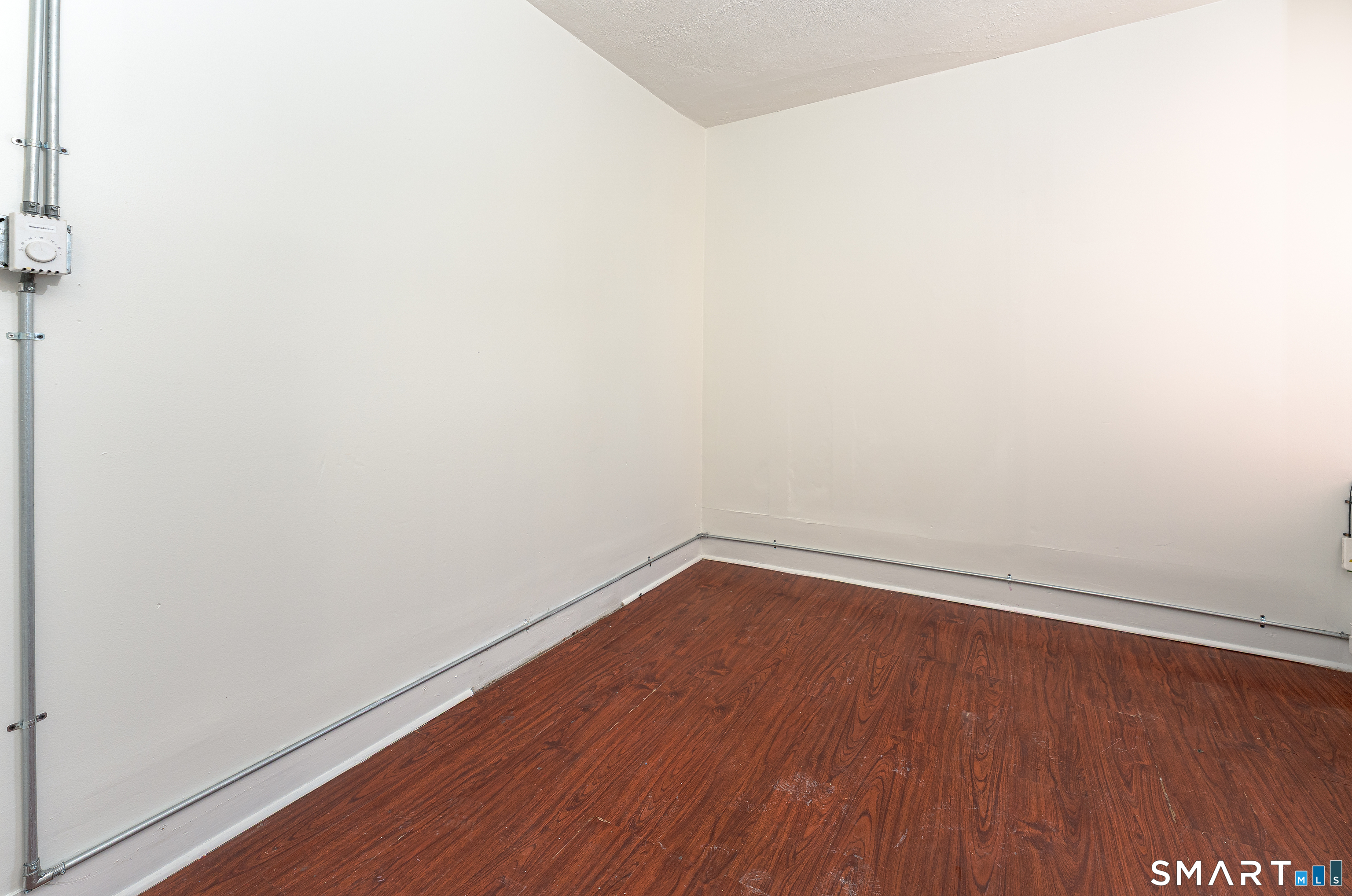 35 Butler Avenue, Unit 5 Bridgeport, CT 06605 - Photo 11 of 25 a view of an empty room with wooden floor and a window