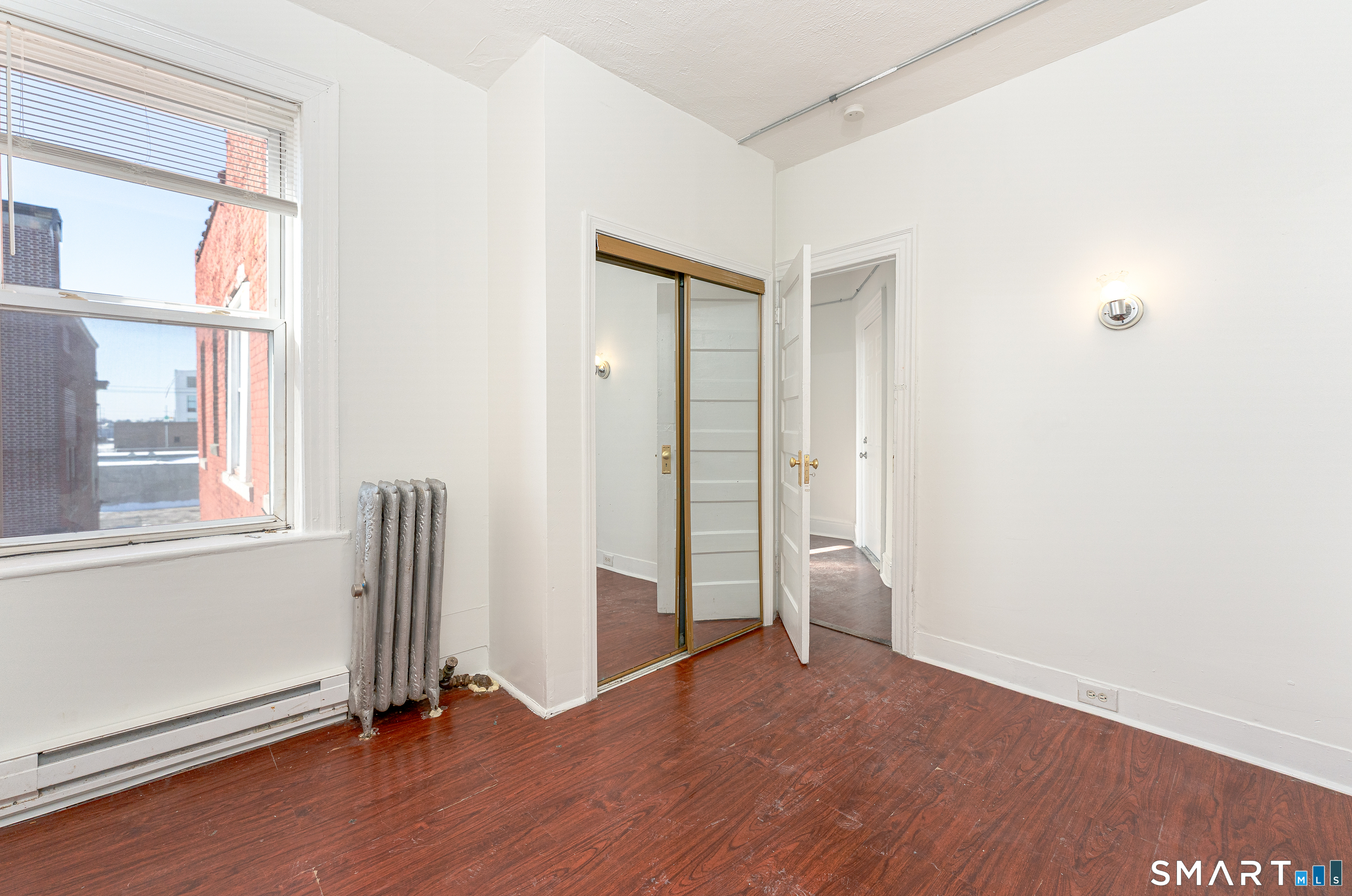 35 Butler Avenue, Unit 5 Bridgeport, CT 06605 - Photo 13 of 25 an empty room with wooden floor and windows