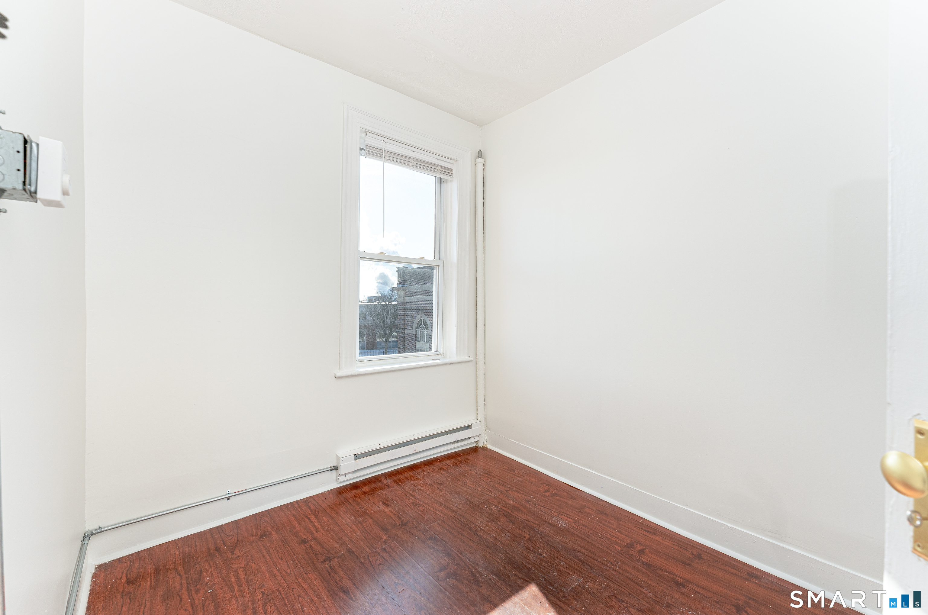 35 Butler Avenue, Unit 5 Bridgeport, CT 06605 - Photo 18 of 25 a view of an empty room with wooden floor and a window