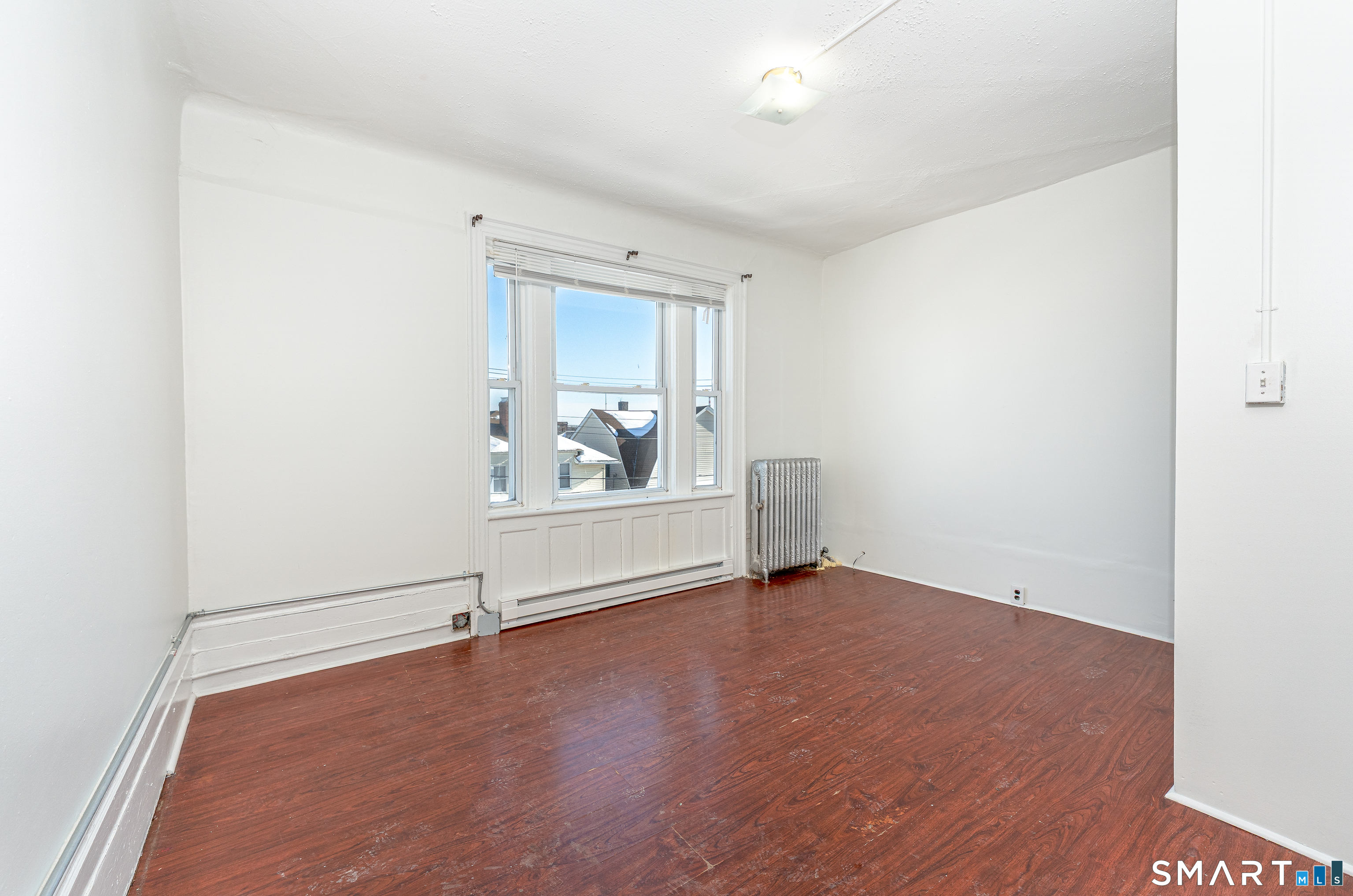 35 Butler Avenue, Unit 5 Bridgeport, CT 06605 - Photo 4 of 25 an empty room with wooden floor and windows