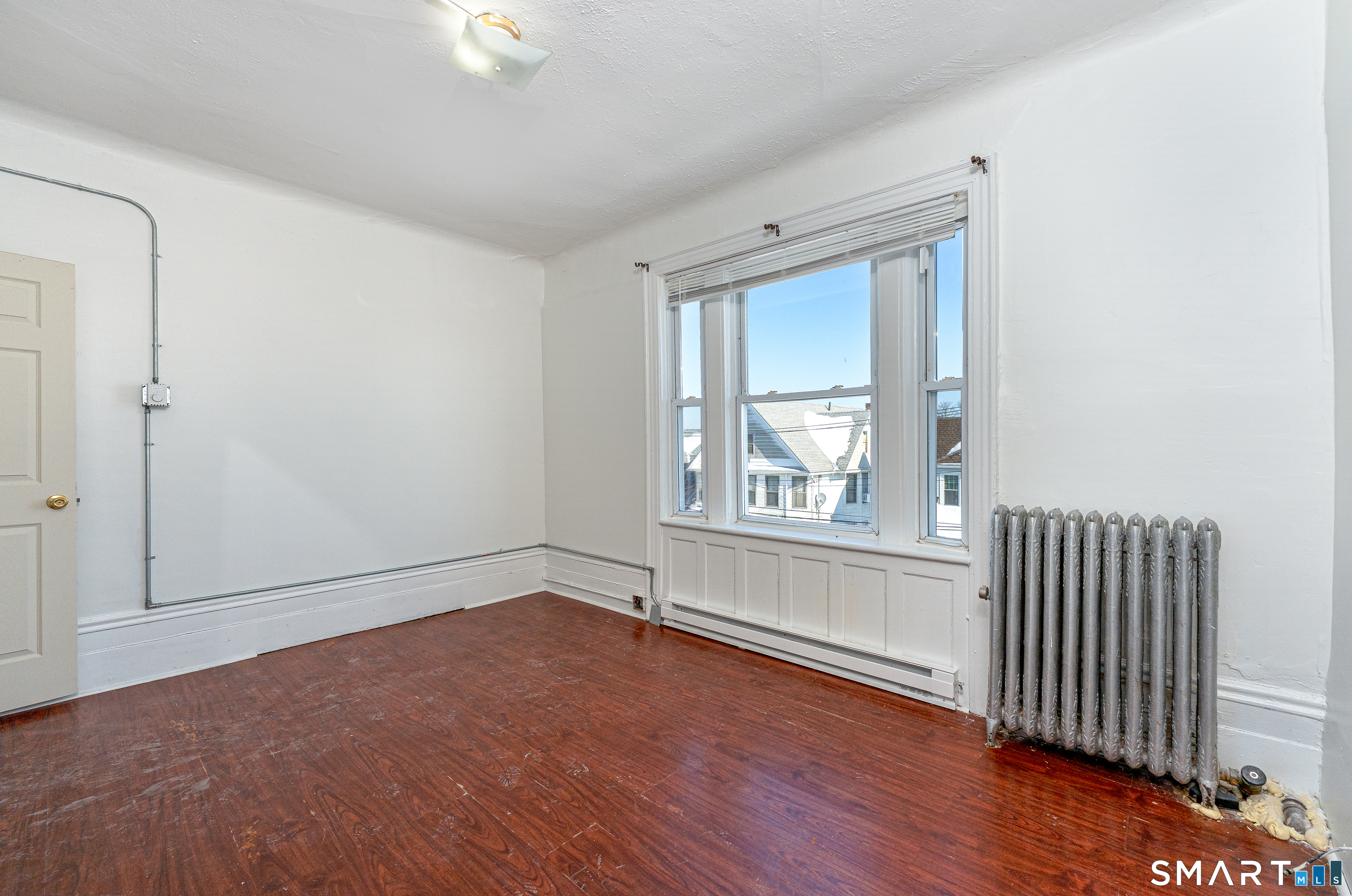 35 Butler Avenue, Unit 5 Bridgeport, CT 06605 - Photo 7 of 25 a view of an empty room with wooden floor and a window