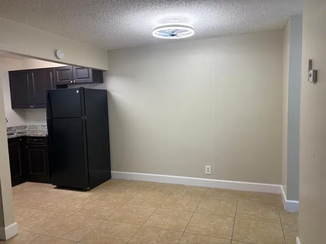 an empty room with a dresser and a window