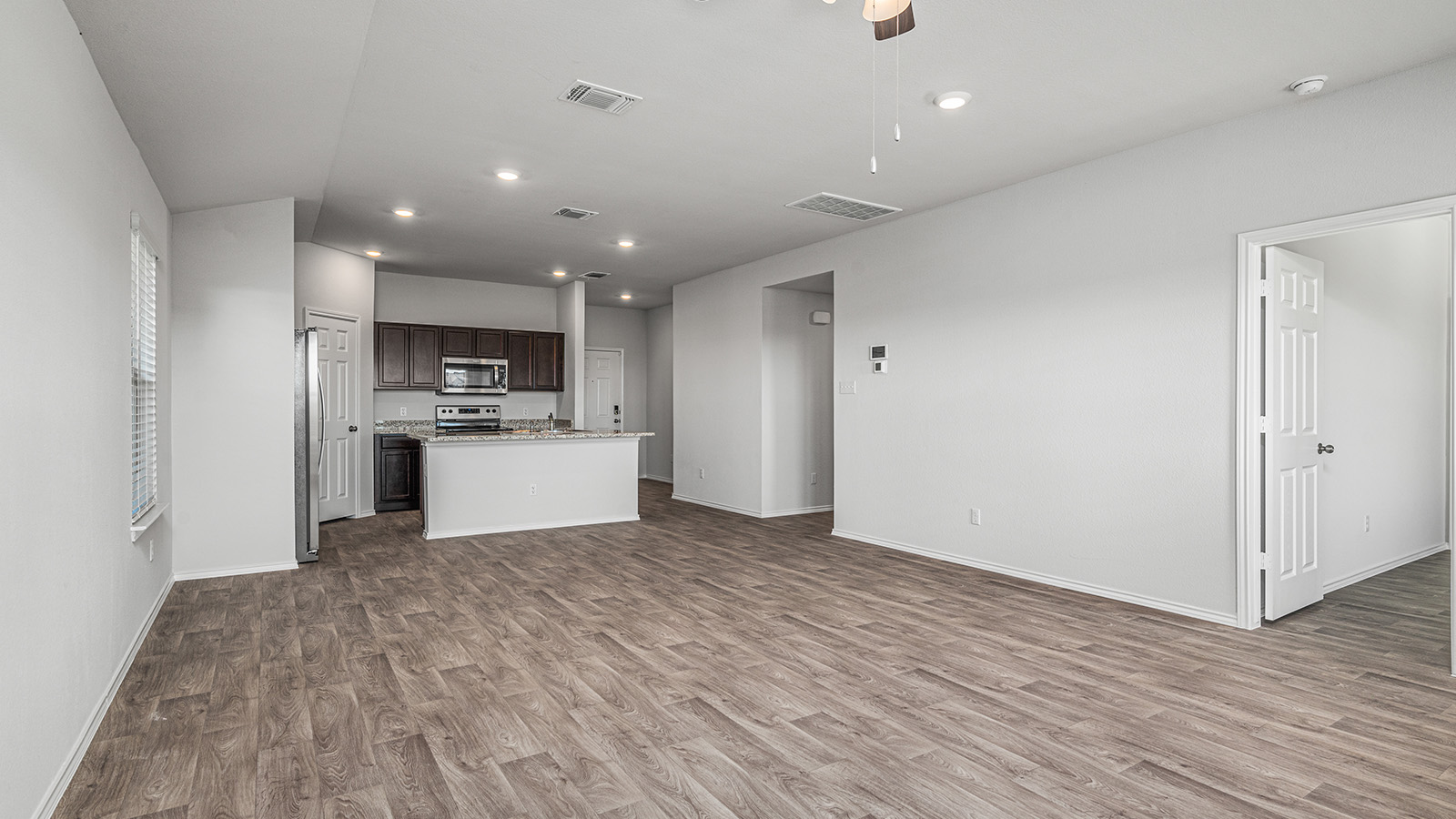 1303 Coriander Road Temple, TX 76501 - Photo 10 of 20 Expansive open-concept living space featuring wood-finish flooring