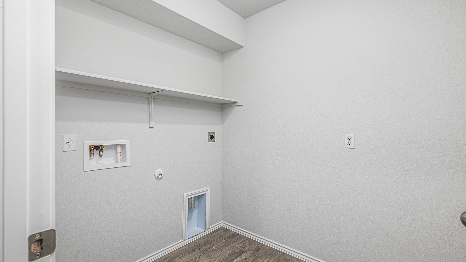 1303 Coriander Road Temple, TX 76501 - Photo 19 of 20 Dedicated laundry area featuring a built-in shelf, wall-mounted water hookups, and wood-finish flooring