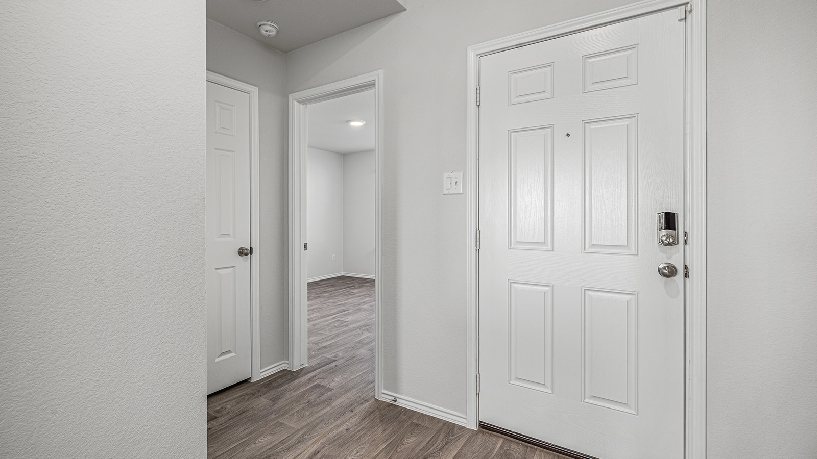 1303 Coriander Road Temple, TX 76501 - Photo 2 of 20 Entryway featuring a white six-panel door, smart lock, light-toned wood-finish flooring, and crisp white walls